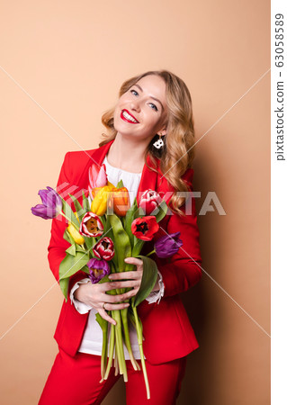Happy beautiful woman posing with flowers and 63058589