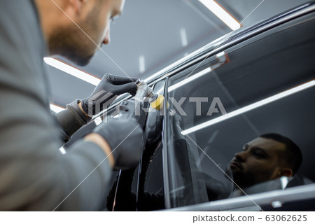 Man polishing vehicle body from scratches 63062625