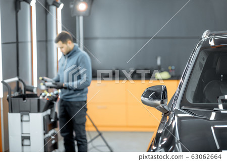 Car service worker preparing for vehicle body detailing 63062664