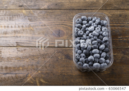 Fresh blueberries in a plastic container. 63066547