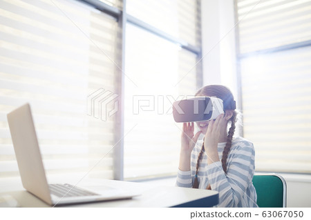 Curious Girl Using VR Glasses Curious Girl Using VR Glasses 63067050