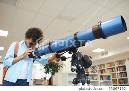 Boy Looking Through Telescope 63067162