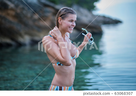 Pretty beautiful woman in white swimwear bikini 63068307