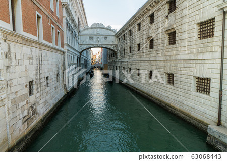 The Bridge of Sighs, famous bridge connects Doge Palace to the prison, in Venice, Italy with gondolas 63068443