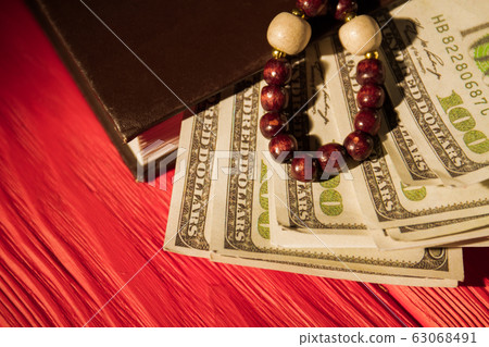 Prayer rosary beads, bible and money. 63068491