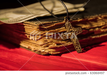 Ornamented decorative golden cross and old book close-up. 63068497