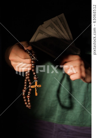 Christian woman with wooden cross necklace and money. Christian woman with wooden cross necklace and money. 63068512