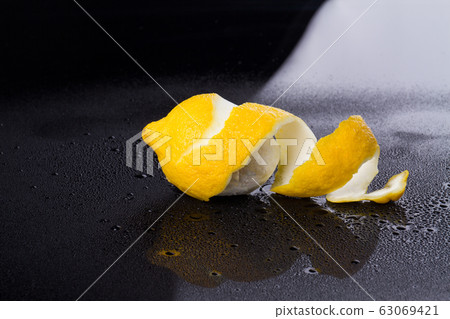 Peeled lemon on wet surface. Peeled lemon on wet surface. 63069421