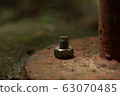 bolt screw nut rusty on concrete floor. 63070485