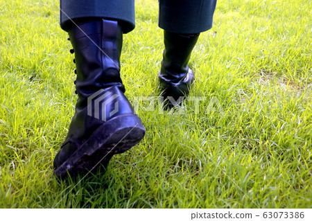 Body part a man walking.He walking on grass background.He wear black shoes.going,move on,fright,develop,Grow up. 63073386