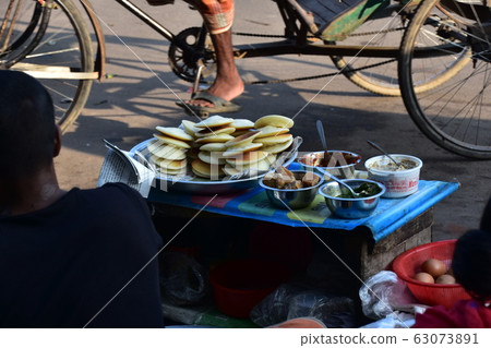 Bangladeshi couple on the street of Dhaka in the morning, Bangladeshi couple selling hot cakes for breakfast Bangladeshi couple on the street of Dhaka in the morning, Bangladeshi couple selling hot cakes for breakfast 63073891