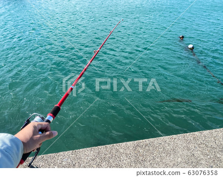 在防波堤上釣魚。 63076358