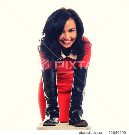 Young slim woman in red dress and brown boots Young slim woman in red dress and brown boots 63080690