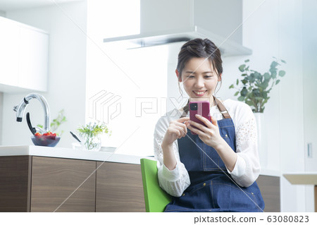 Young woman, living dining, smartphone, search 63080823