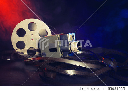 retro 8 mm movie camera with a reel of film in retro 8 mm movie camera with a reel of film in 63081635