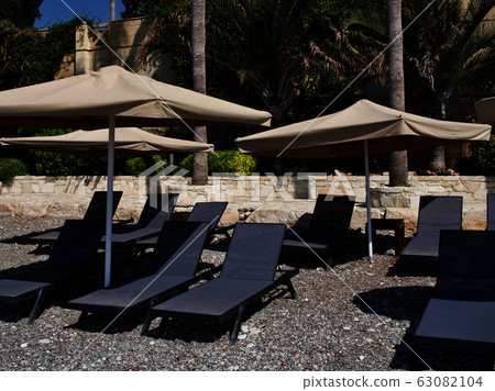 Umbrellas and sunbeds for relaxing on the beach 63082104