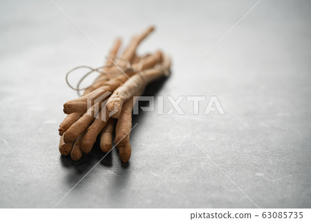 bunch of handmade wholegrain grissini tied with rope on concrete surface with copy space 63085735