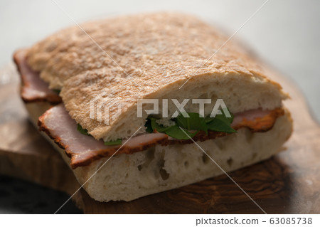 sandwich with smoked pork, spinach and pesto on olive wood board sandwich with smoked pork, spinach and pesto on olive wood board 63085738
