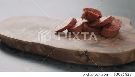chorizo slices on olive wood board closeup 63085828
