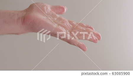 pour shower gel on man hand closeup 63085900