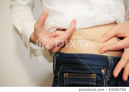 Woman doing self injection Woman doing self injection 63086798