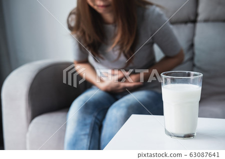 Woman having bad stomach ache with a glass of Woman having bad stomach ache with a glass of 63087641