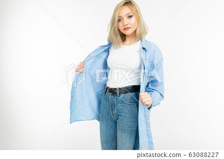 smiling romantic girl in a stylish blue denim shirt posing on a white background with copy space 63088227
