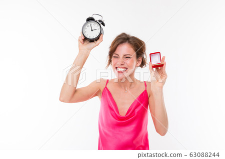 Young beautiful girl holds a box for a engagement ring and shows it on her hand isolated on white Young beautiful girl holds a box for a engagement ring and shows it on her hand isolated on white 63088244