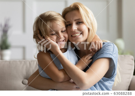 Portrait of happy young mom and little daughter cuddling 63088288