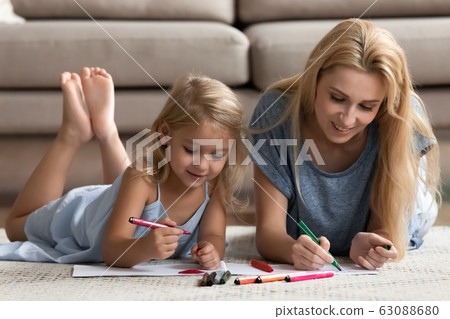 Happy young mom drawing together with small daughter Happy young mom drawing together with small daughter 63088680