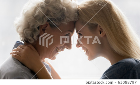 Loving mature mom and adult daughter enjoy close moment 63088797
