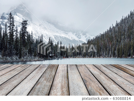 Empty wood plank on blurred snowy on pine forest 63088814