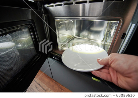 Hand putting empty plate Hand putting empty plate 63089630