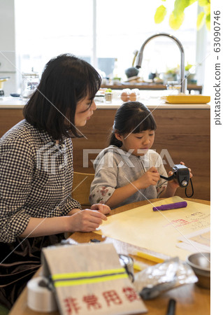 Children studying how to use a disaster prevention radio at a family disaster prevention meeting Children studying how to use a disaster prevention radio at a family disaster prevention meeting 63090746