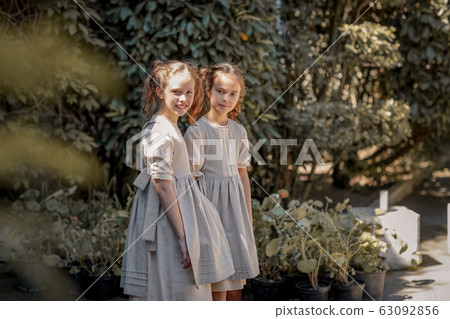Two girls in school clothes have fun and play on the streets during the change Two girls in school clothes have fun and play on the streets during the change 63092856