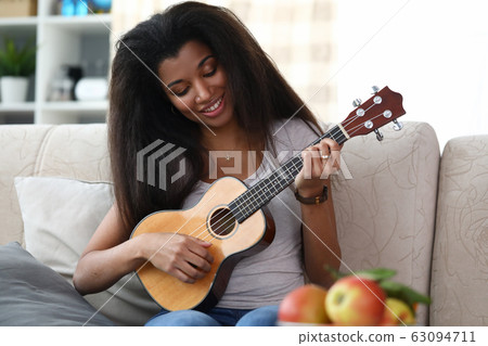 Pretty happy lady sitting on sofa 63094711