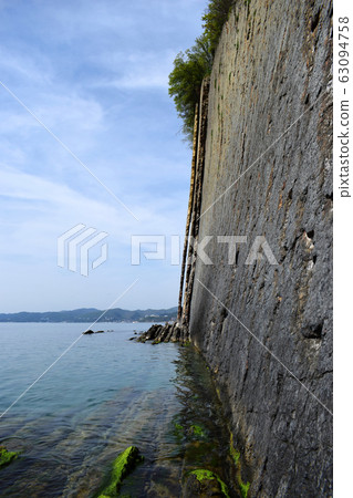 Side view of the Kiselev rock on The black sea coast. Natural stone wall created by nature . Flat rock. Beautiful view of the coast. Side view of the Kiselev rock on The black sea coast. Natural stone wall created by nature . Flat rock. Beautiful view of the coast. 63094758