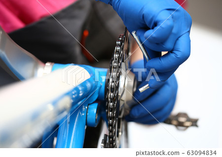 Male mechanic repairing damaged bike Male mechanic repairing damaged bike 63094834