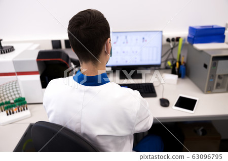 Male researcher in lab coat working in science laboratory 63096795