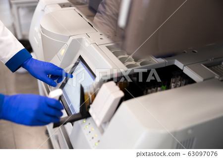 Researcher is using immunoassay analyzer in laboratory Researcher is using immunoassay analyzer in laboratory 63097076