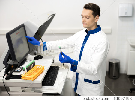 Handsome male researcher doing biochemical blood test in lab Handsome male researcher doing biochemical blood test in lab 63097198
