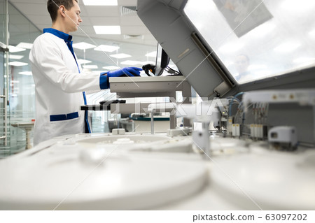 Male researcher using advia immunoassay system in lab Male researcher using advia immunoassay system in lab 63097202
