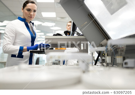 Female researcher using advia immunoassay system in lab Female researcher using advia immunoassay system in lab 63097205
