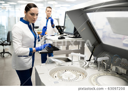 Young scientist using advia immunoassay system in lab Young scientist using advia immunoassay system in lab 63097208