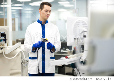 Handsome young scientist doing pathology blood test in lab Handsome young scientist doing pathology blood test in lab 63097217
