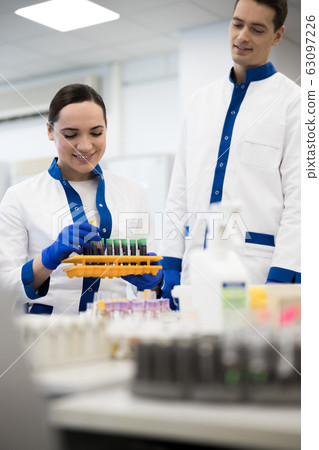 Smiling research scientists doing blood tests in science lab 63097226