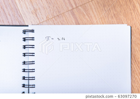 The number pi is written in a notebook with a pen. Pi day number concept. pi is 3.14 The number pi is written in a notebook with a pen. Pi day number concept. pi is 3.14 63097270