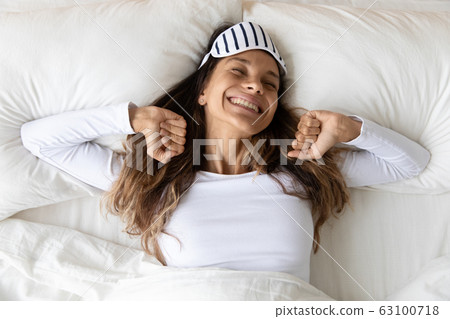 Happy millennial girl stretching awaken in bedroom 63100718