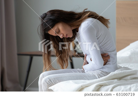 Sick millennial girl suffer from stomach ache at home 63100719