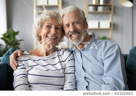 Portrait of happy old couple hug relaxing on couch 63102083